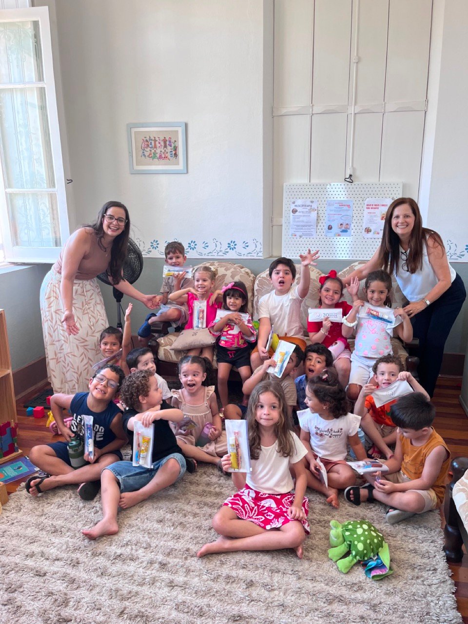 Crianças da Oficina do Sorriso da Musicalisa reunidas no sofá com escovas de dente