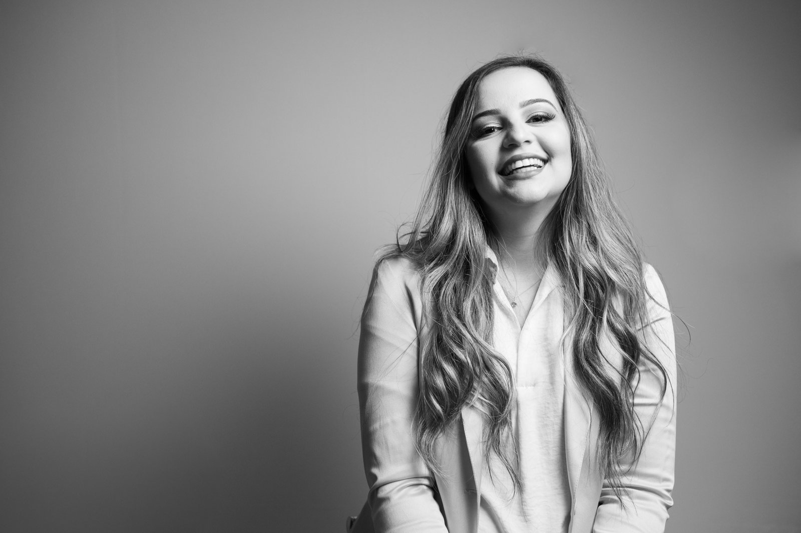 Isa Oliveira sorrindo, retrato de estúdio preto e branco